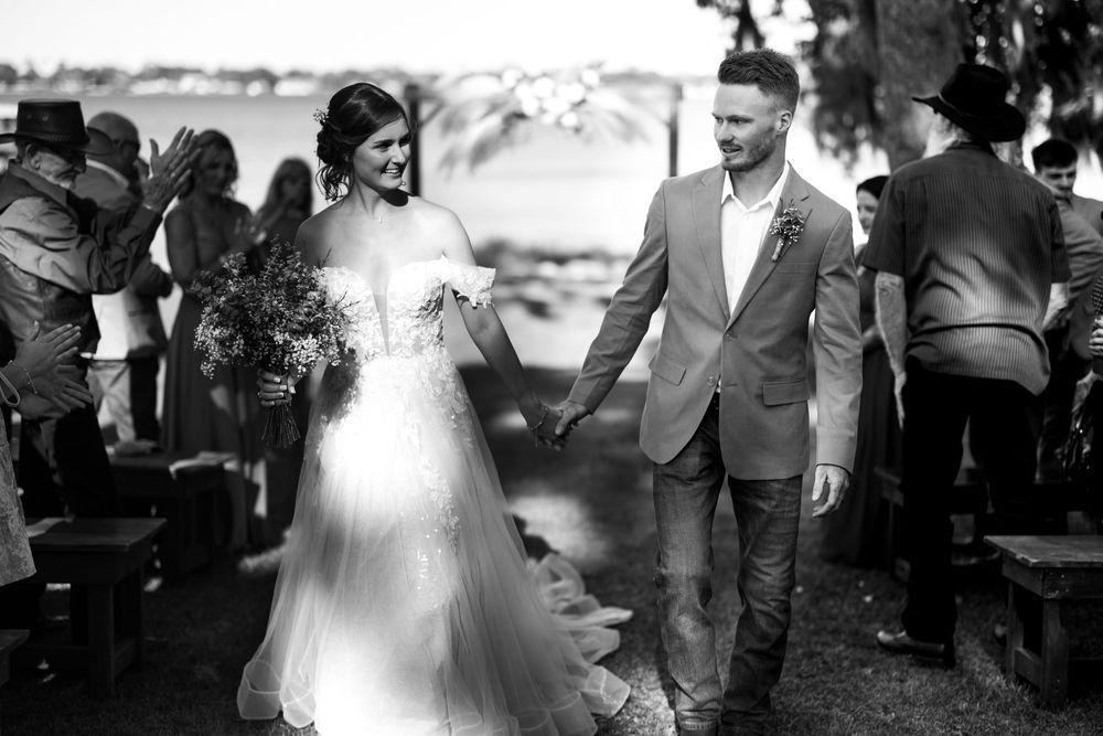 A collage of five black and white wedding photos showing ceremony and celebration moments outdoors.