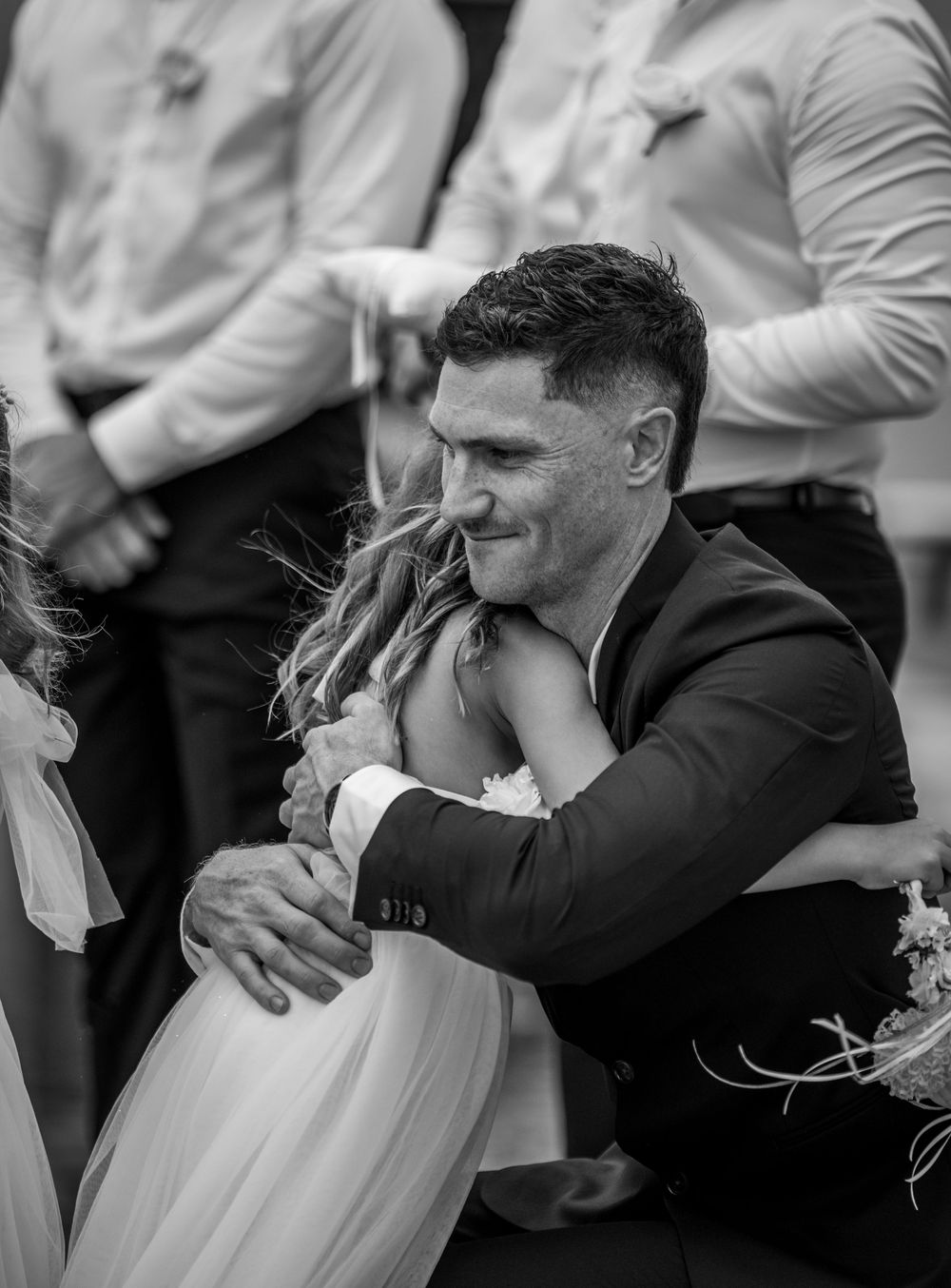 Black and white sequence showing emotional embrace at a wedding ceremony.