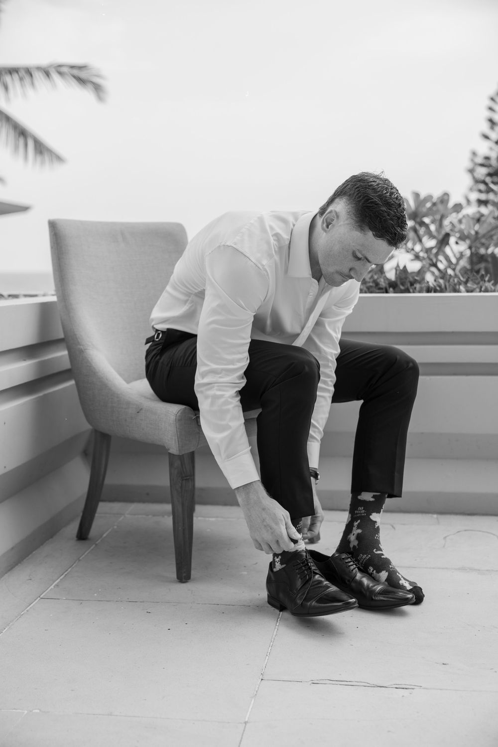 A series of black and white photos showing someone tying elegant dress shoes while sitting on a bench.