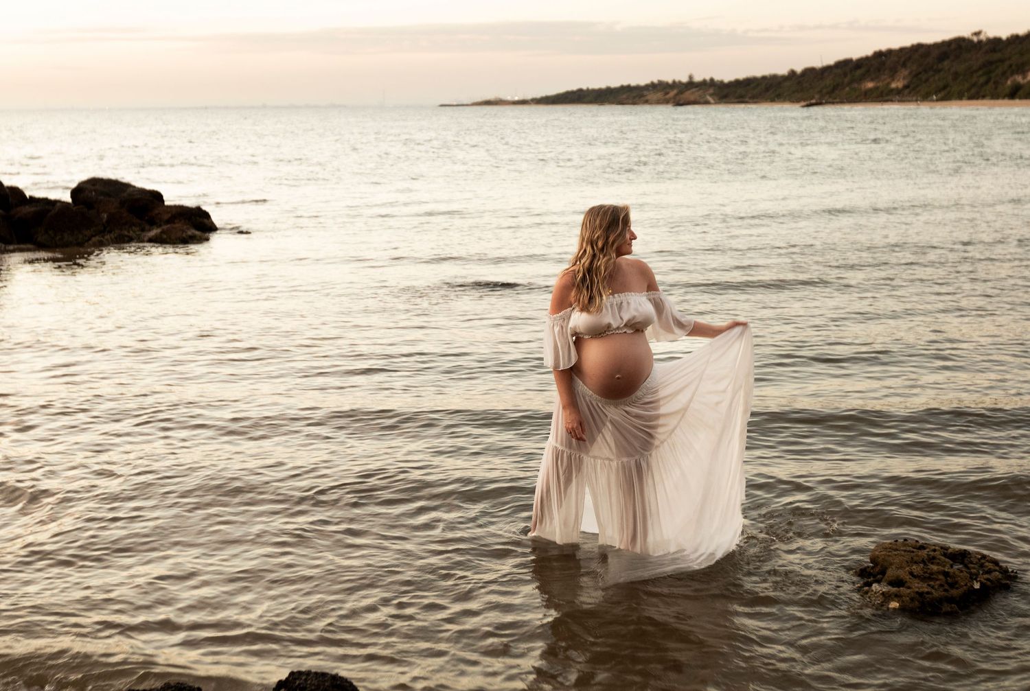 Ethereal sunset photos at a beach with flowing dress and romantic silhouettes against the ocean waves.