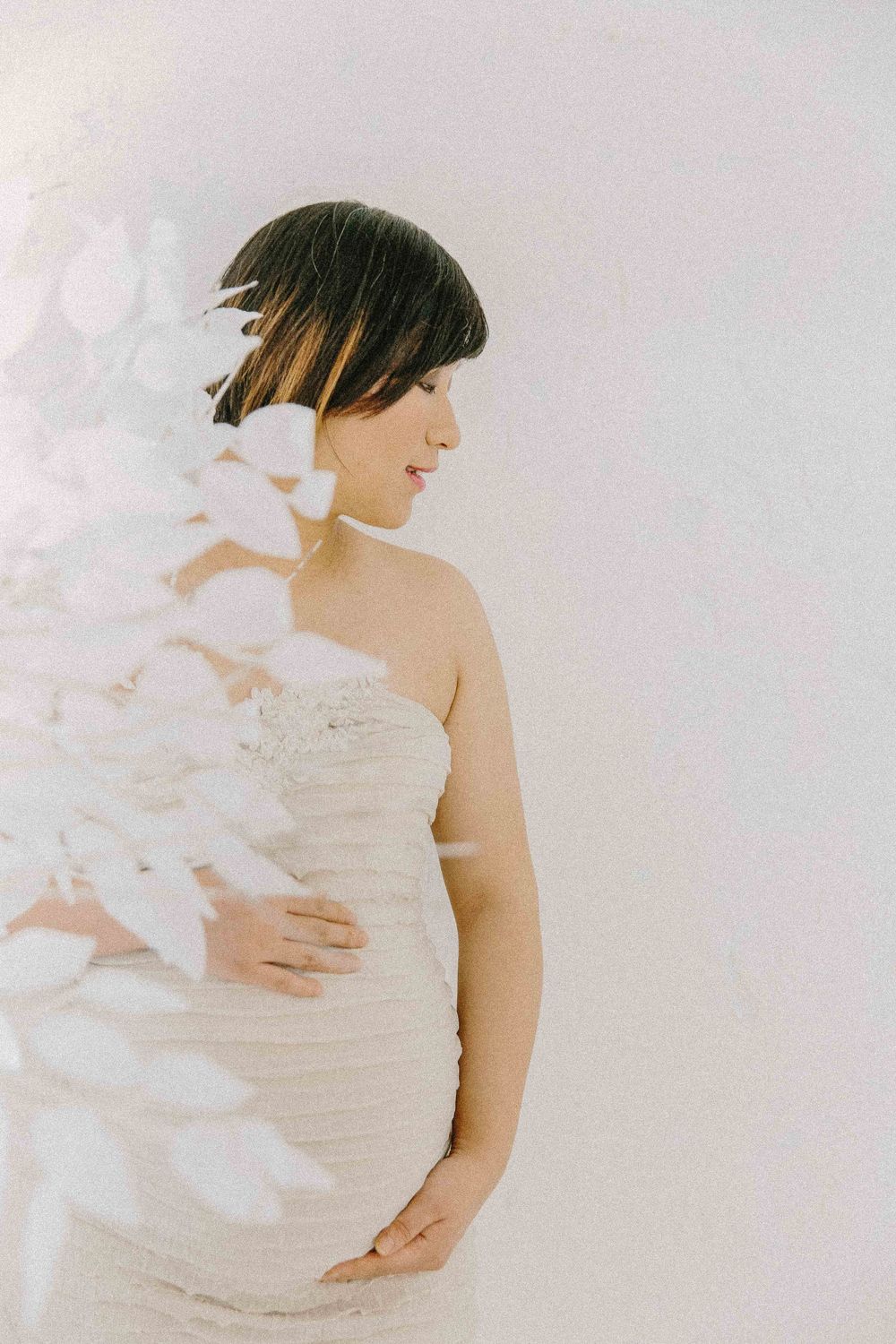 Maternity monochromatic portraits showing tender embraces in flowing white fabric. Alenquer, Lisbon, and Portugal photography studio.