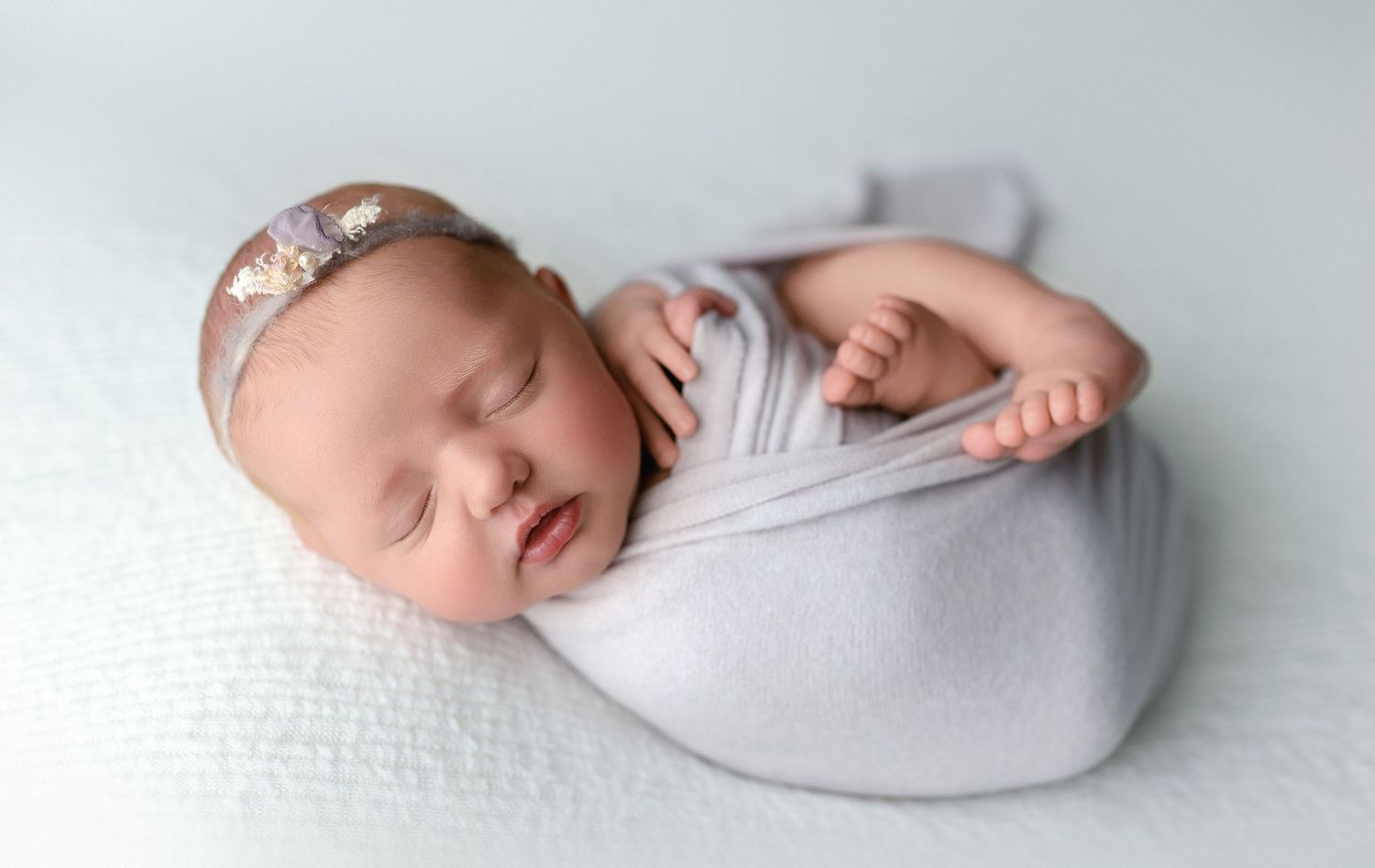 Newborn baby girl in a light purple wrap.  - Greenville SC newborn photographer - Easley SC newborn photographer