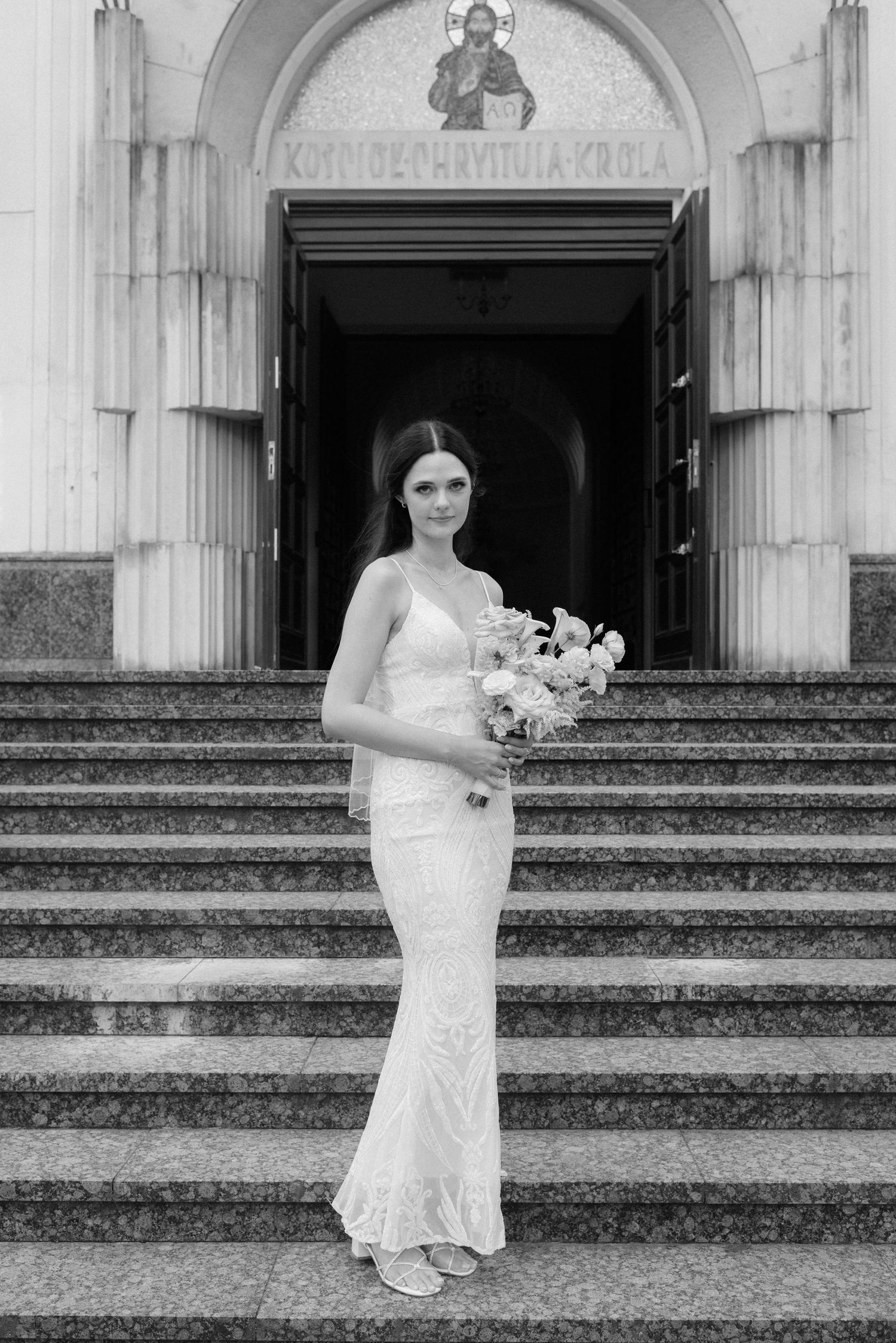 Progressive sequence of bride descending stone church steps while holding bouquet in elegant white dress.