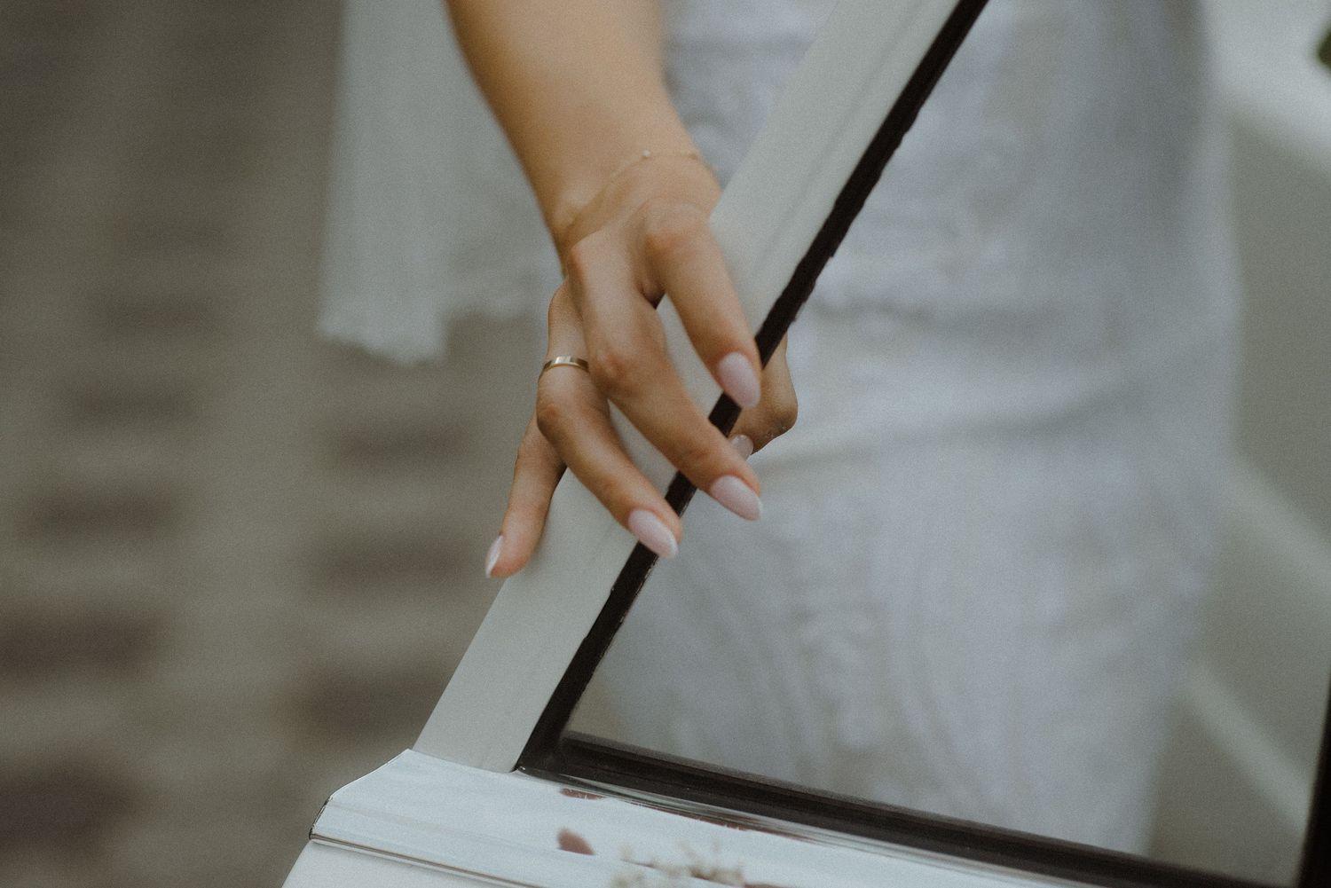 A hand lighting a white candle with a match in a minimalist setting.