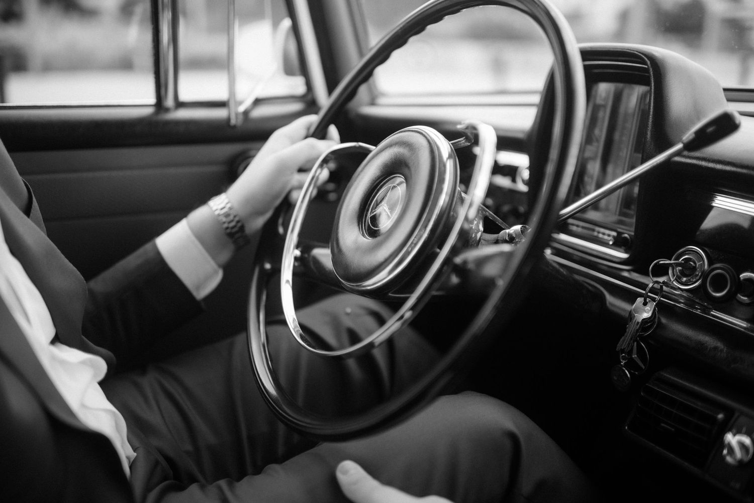 Black and white detail shots of vintage car interior and steering wheel.