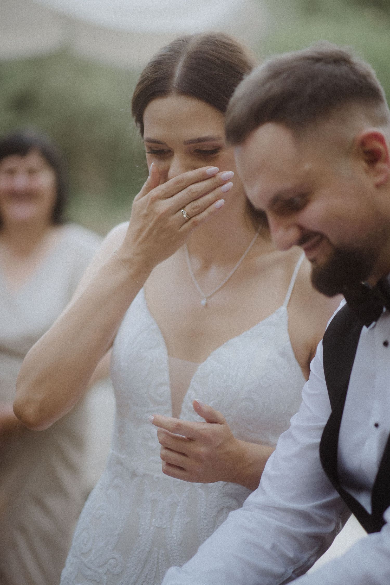 Emotional moment captured during wedding ceremony with couple sharing laughter.