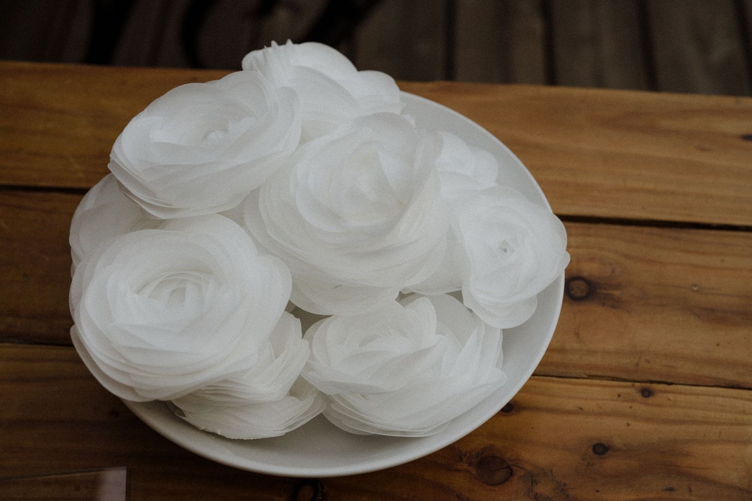 White meringue cookies or pavlova nests arranged on a rustic wooden table.