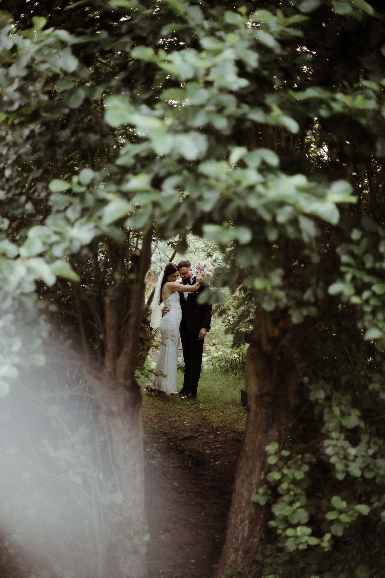 Romantic woodland wedding scene with soft natural lighting filtering through trees.