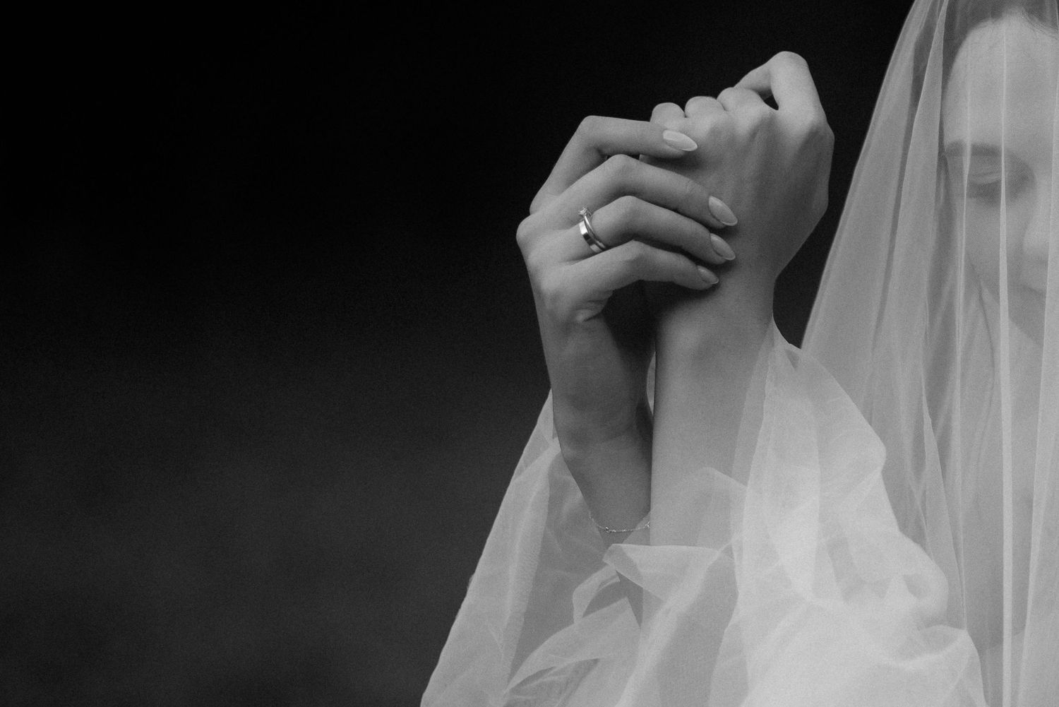 Close-up shot of a flowing white bridal veil with soft natural light creating ethereal texture.