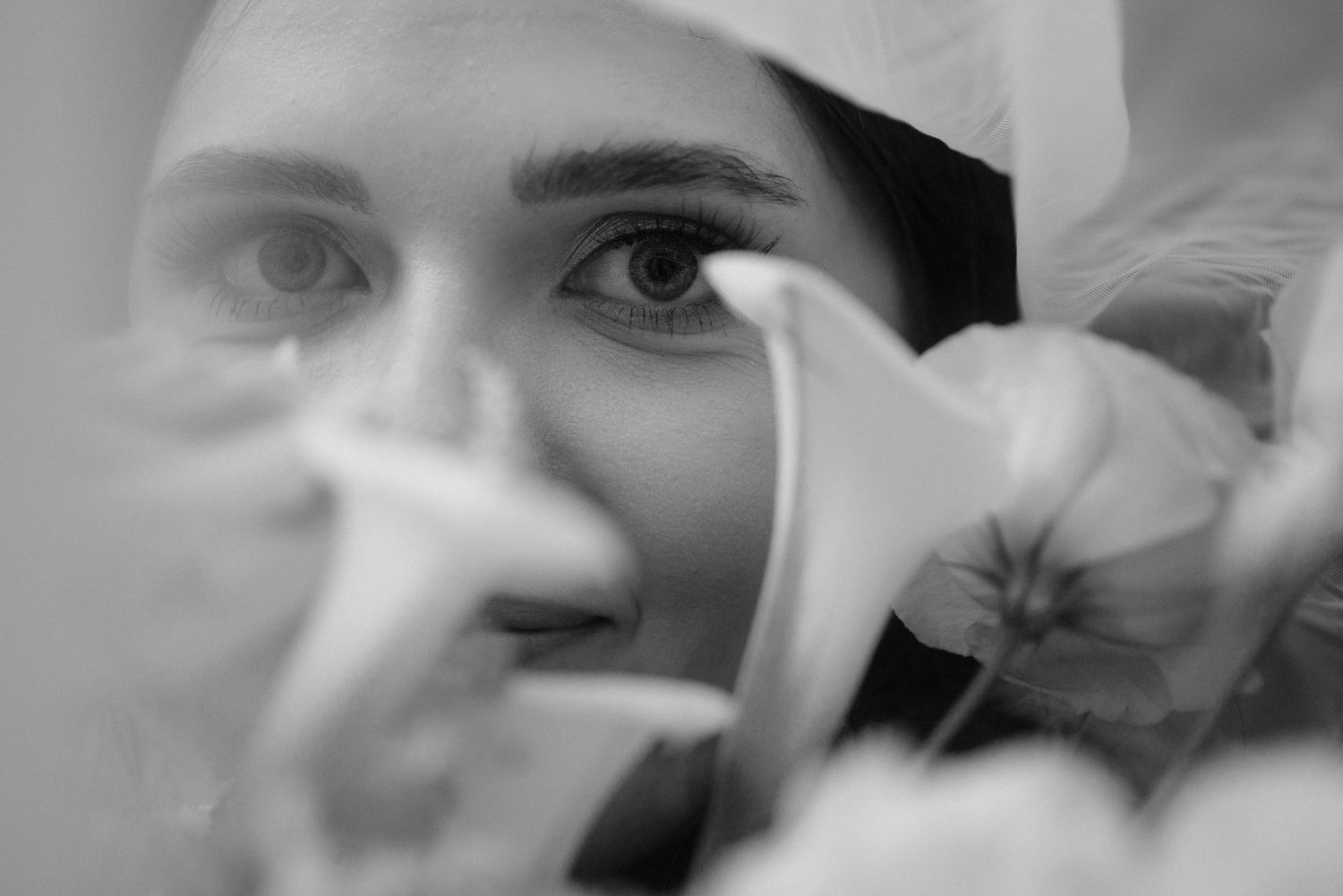 Close-up black and white wedding photography shot with soft focus and dreamy lighting.