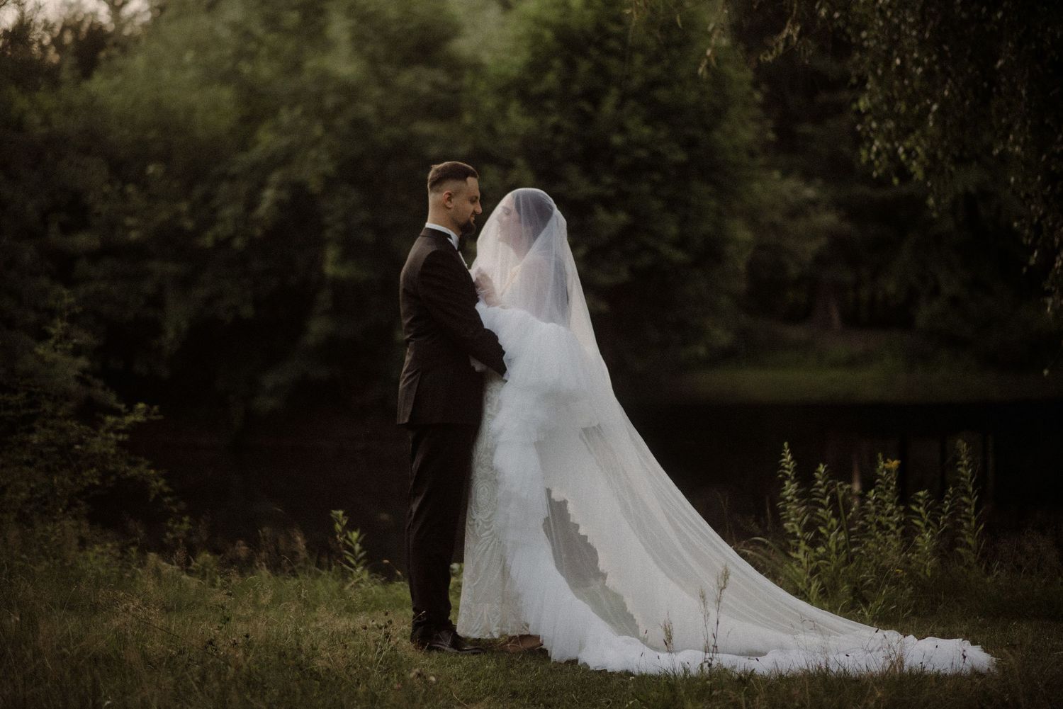 Romantic silhouette of wedding couple walking through natural outdoor setting.