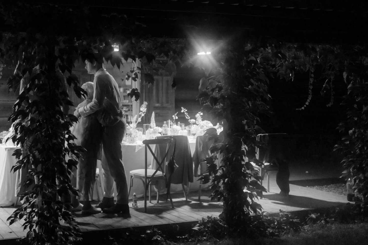 Wedding party celebration under twinkling night lights in outdoor garden setting.