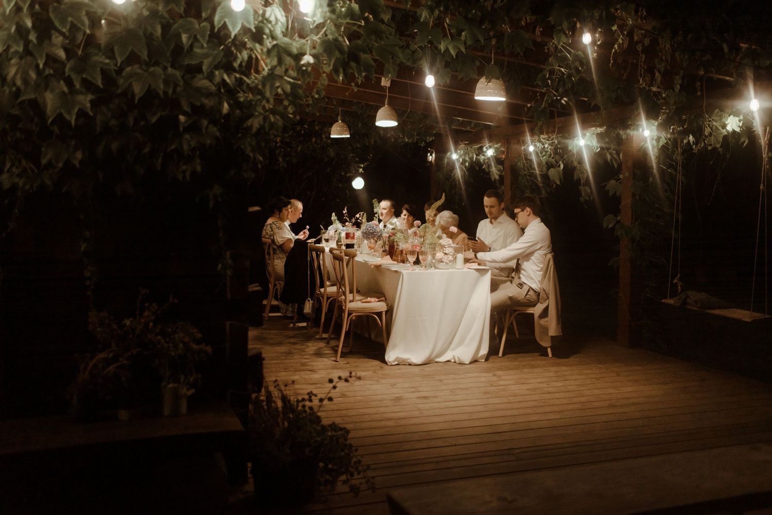 Outdoor evening wedding reception with string lights creating warm ambiance.