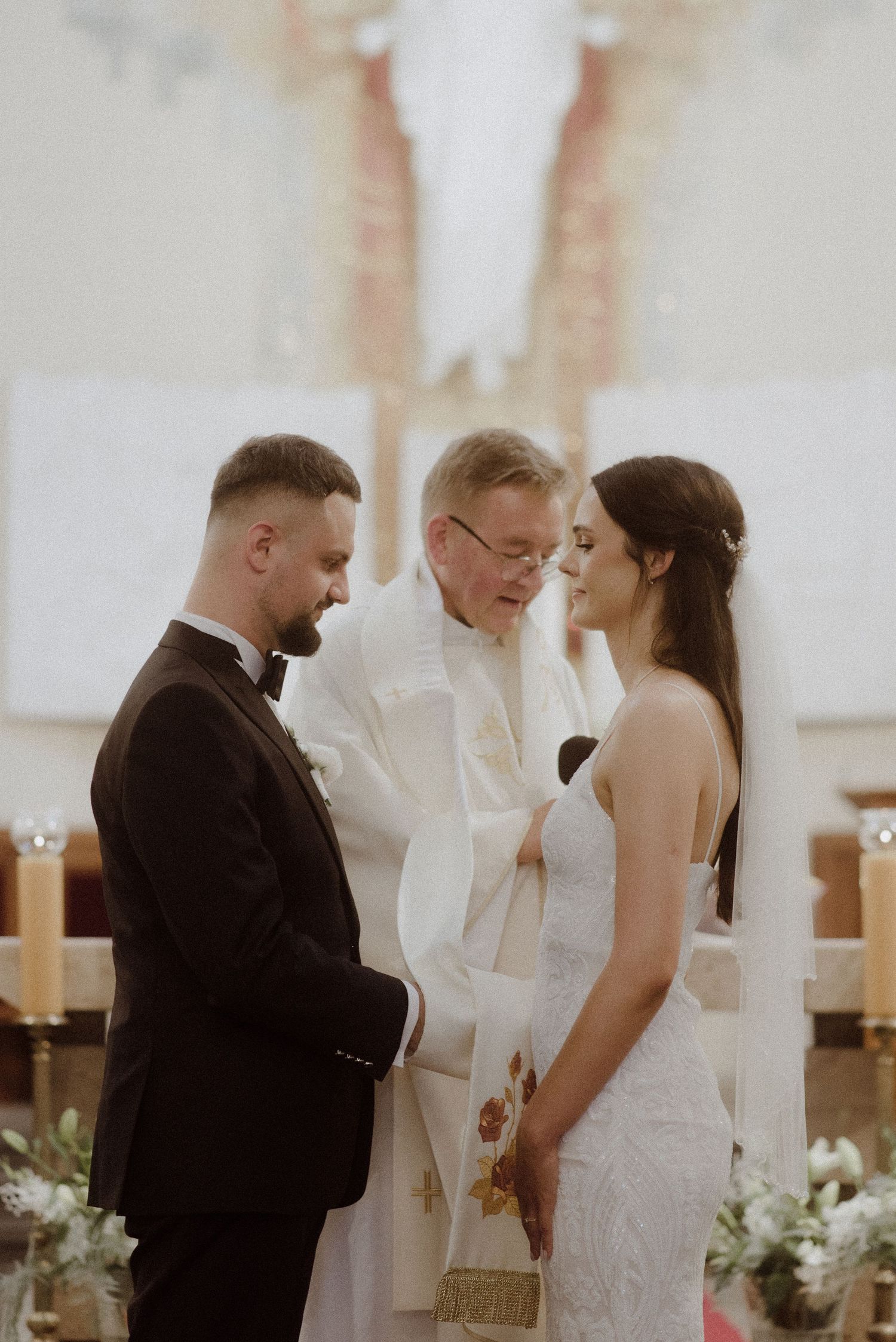 Wedding ceremony moments showing emotional exchange between couple and officiant at indoor venue.