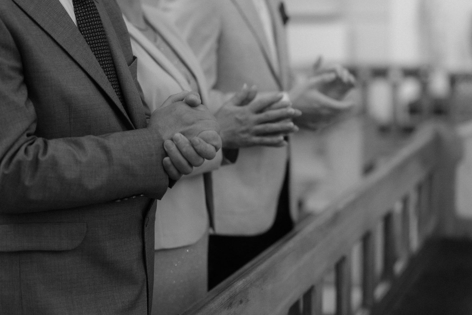 Black and white capture of bride and groom exchanging rings during church ceremony.