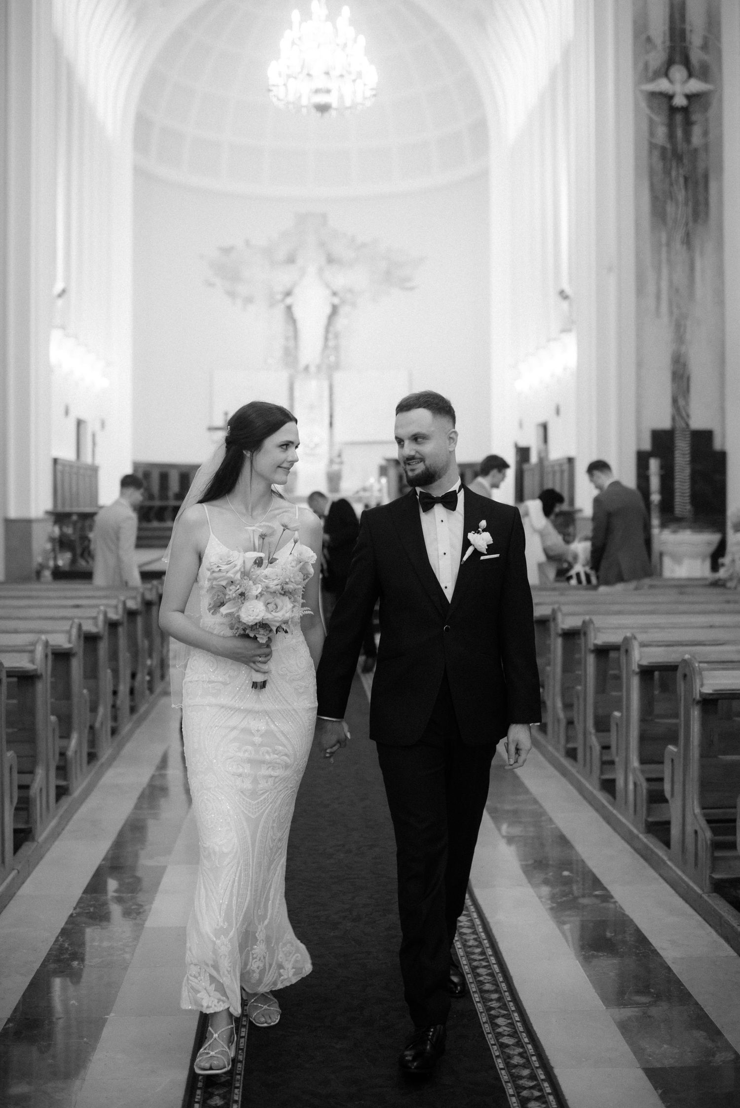 Black and white photo series of a couple walking down church aisle after their wedding ceremony.