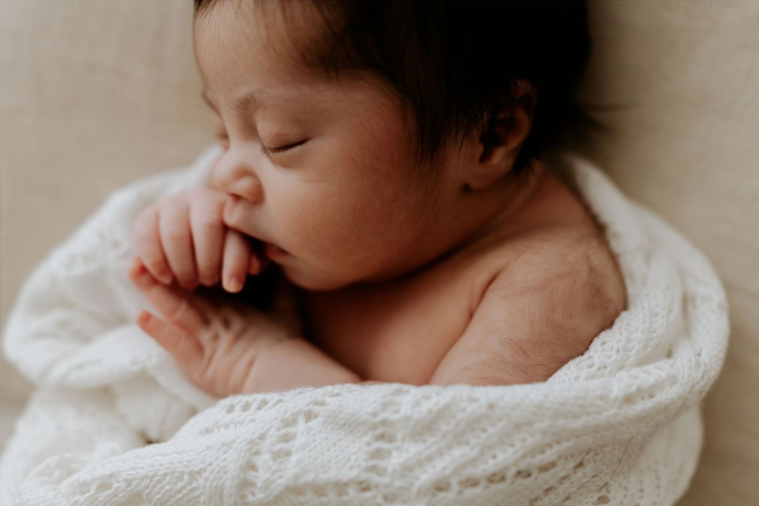 Adelaide photographer captures a tender portrait of a mother cradling her newborn baby in her photography studio in Tea Tree Gully.