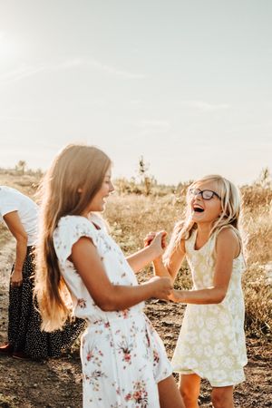 Children playing and laughing together in a sunlit field.