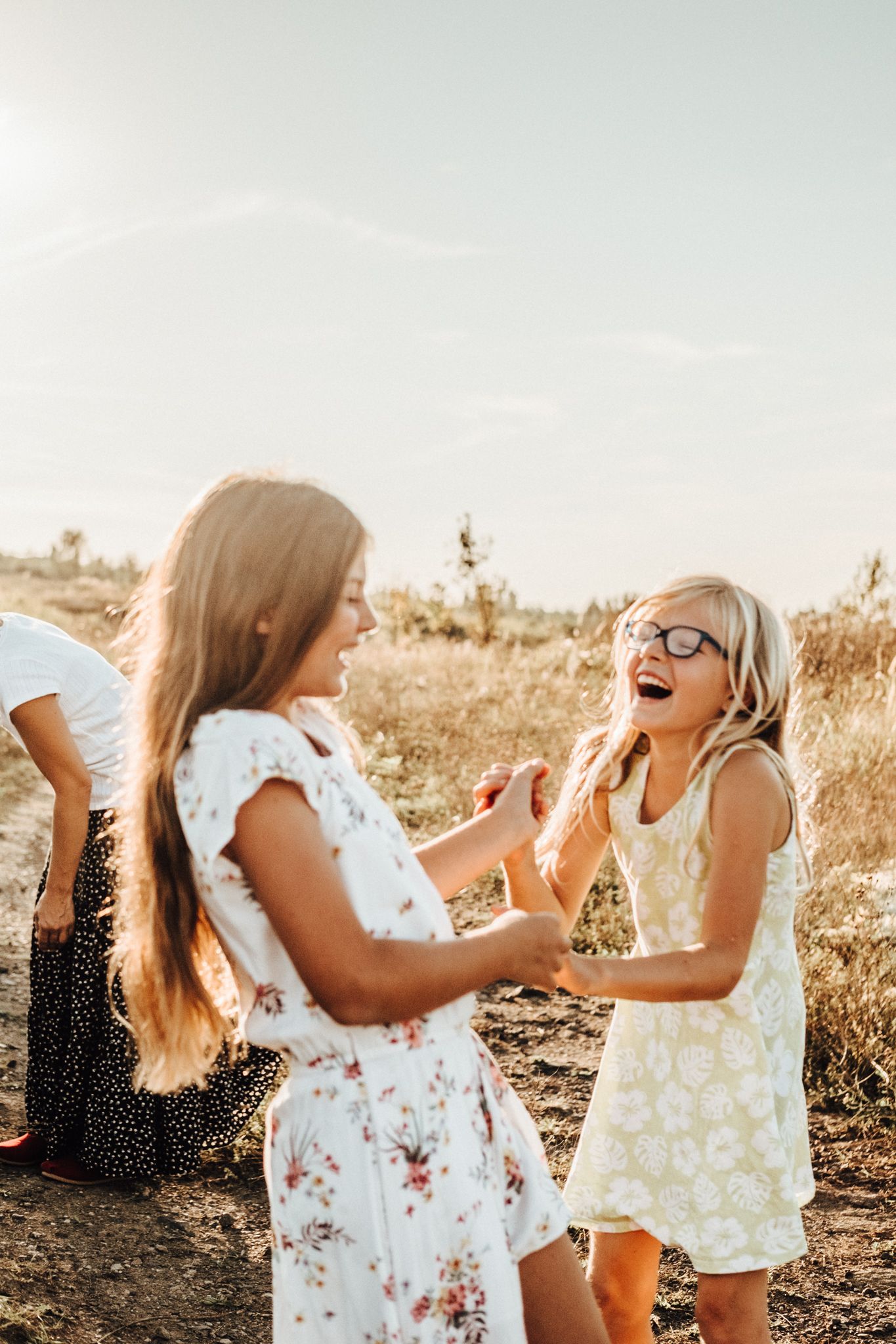 Children playing and laughing together in a sunlit field.