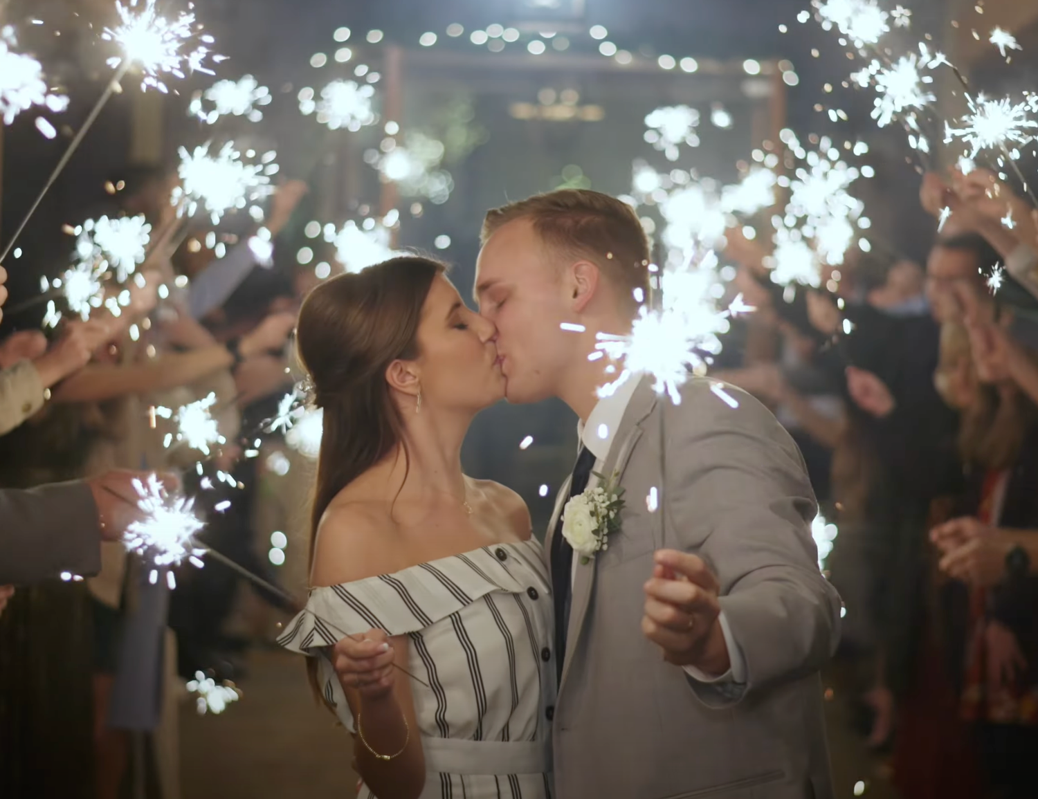 Wedding celebration with sparklers creating magical light trails in the dark.