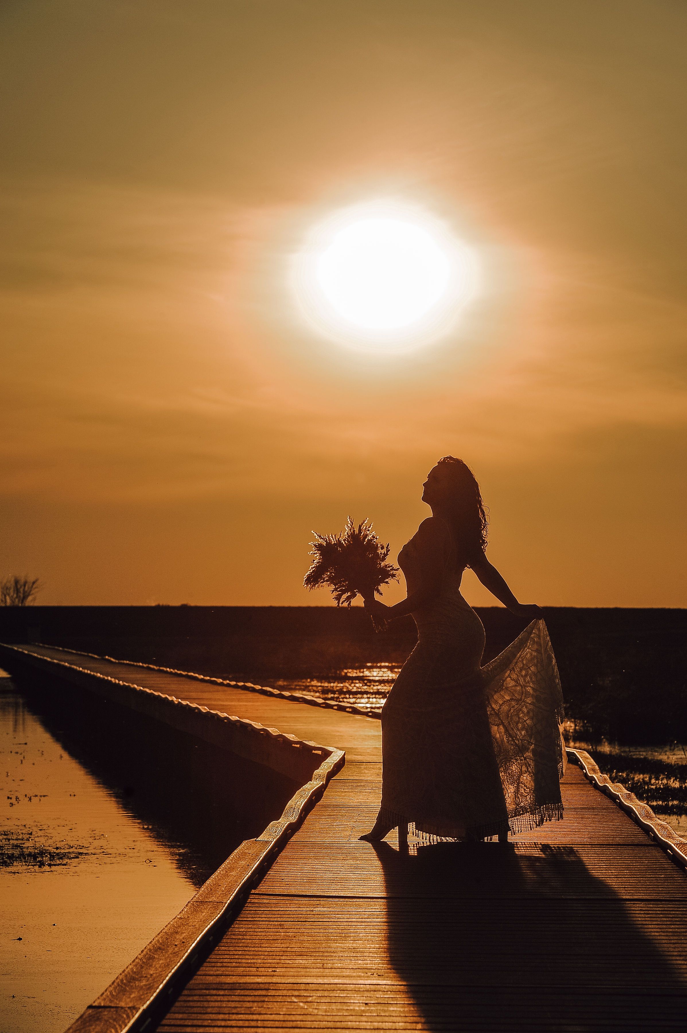 Silhouettes on boardwalk at sunset create dramatic orange-tinted sequence.