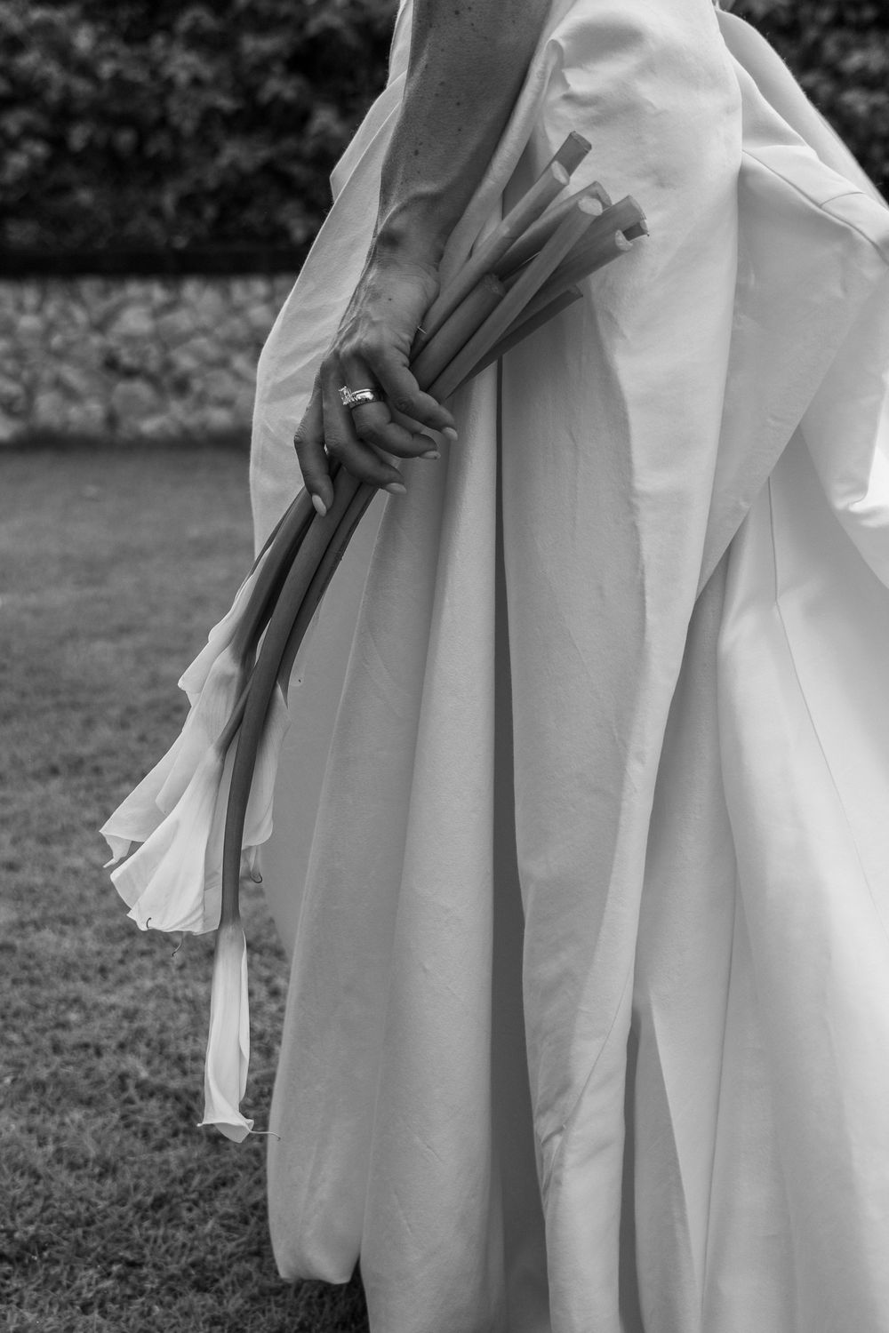 Black and white photograph showing close-up details of pleated white fabric from a wedding dress.