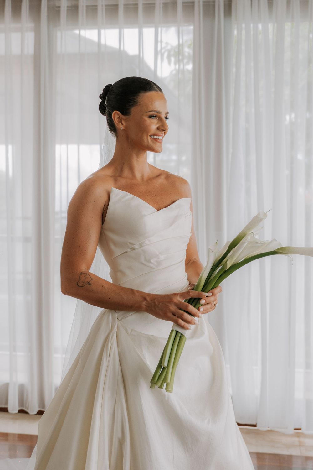 Four sequential photos show someone in a white wedding gown holding a bouquet with lush curtains in the background.
