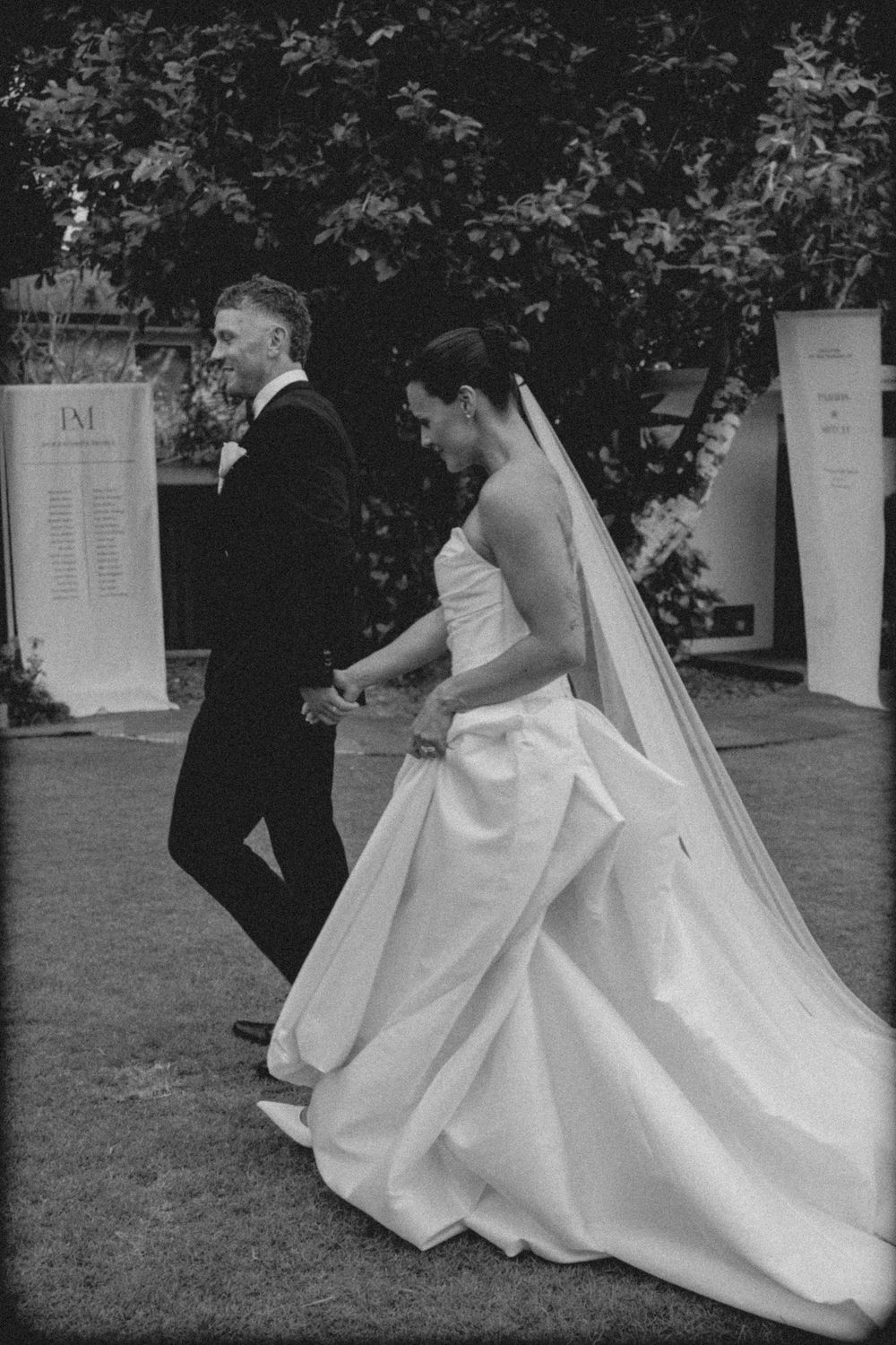 Black and white wedding photos show couple dancing where bride's elegant white ballgown dress twirls gracefully outdoors.