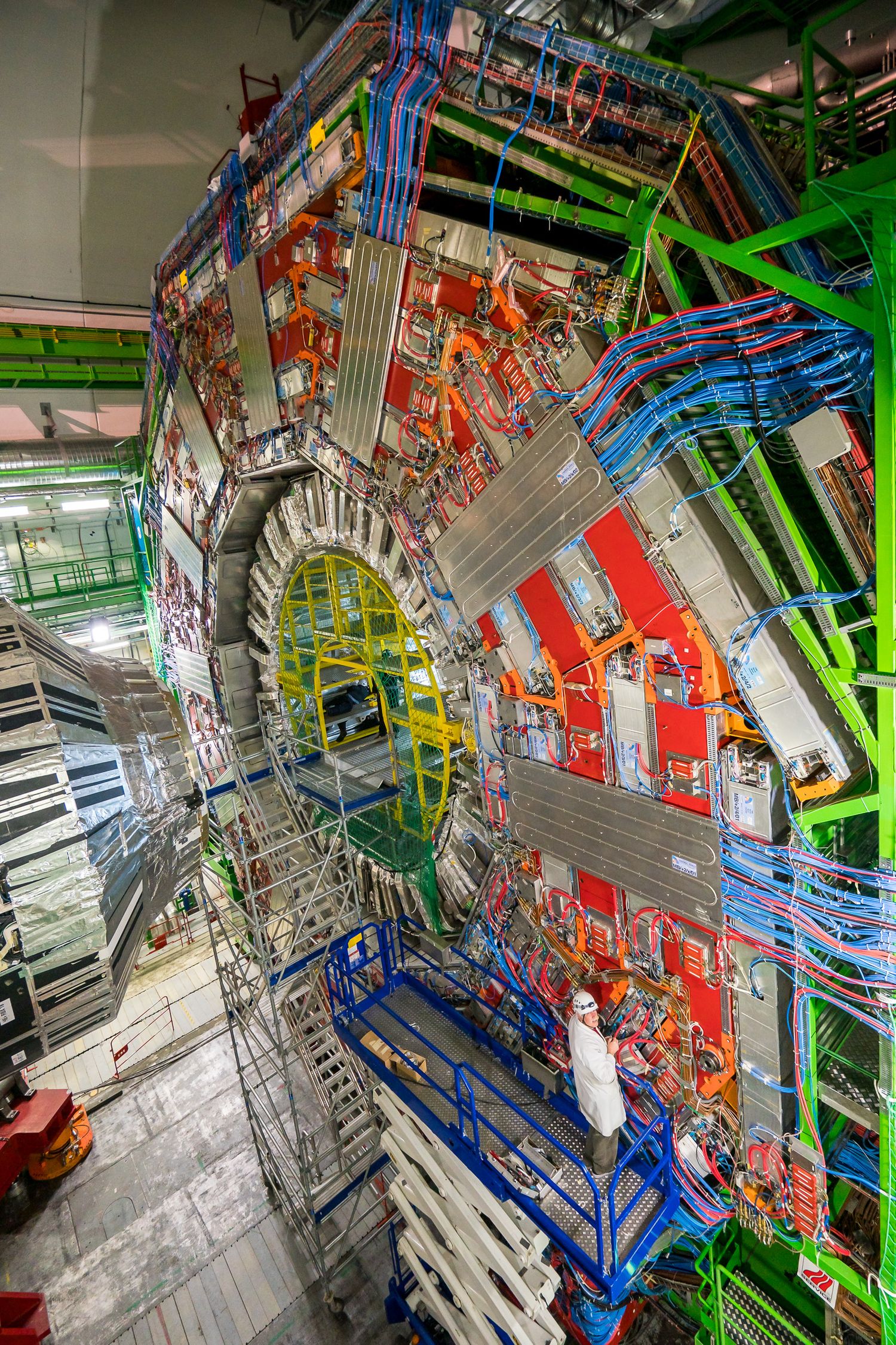 Scientist operates complex laboratory equipment with vacuum chambers and precision instruments in research facility.