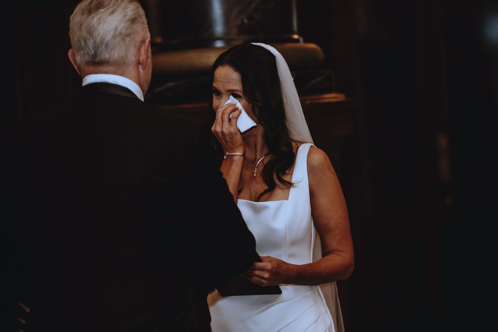 Couple sharing an intimate dance moment at a wedding reception under warm lighting.