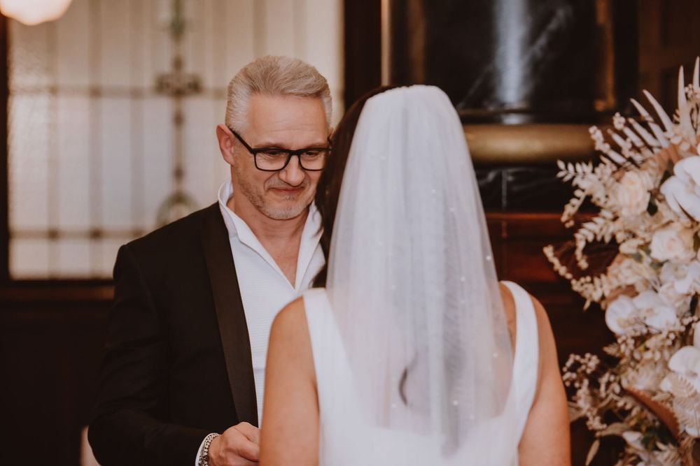 A series of wedding photos showing moments from a couple's intimate indoor ceremony with soft lighting and floral decor.