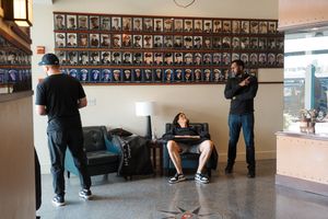 School hallway with rows of framed photos and class portraits displayed on wall running length of corridor.