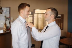 Two people in white button-down shirts have an animated discussion in an office setting.