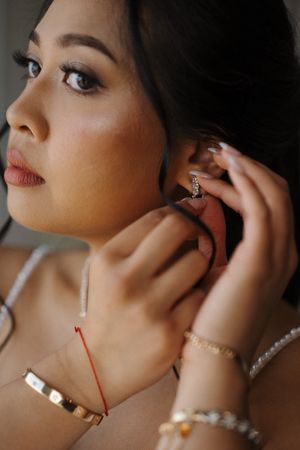 A series of close-up shots showing delicate jewelry and makeup details in dramatic lighting.