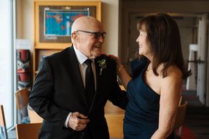 A sequence of formal attire adjustments showing someone straightening a tie and boutonniere in preparation for an event.