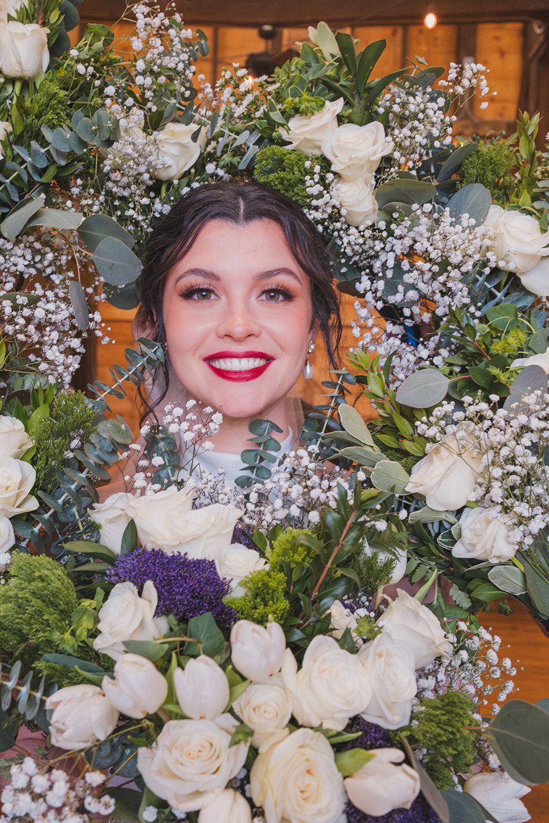 Bridal portrait framed by elegant white roses and delicate baby's breath floral arrangement.