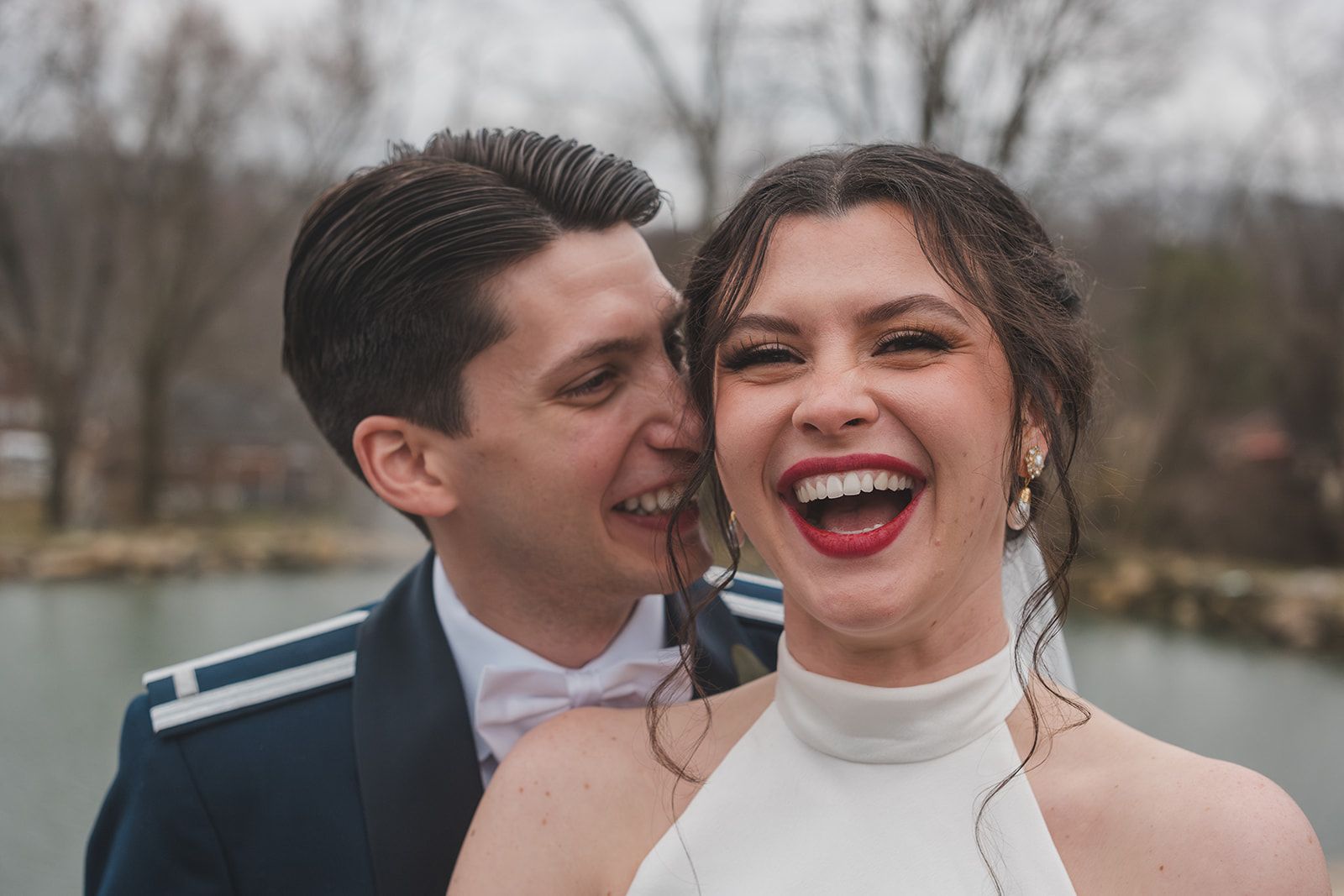 A joyful couple shares a tender moment on their wedding day, with bride wearing a high-neck white dress and groom in formal attire.
