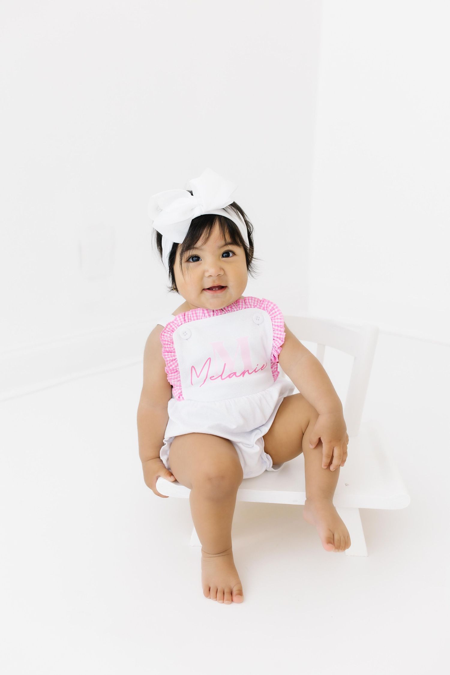 Three photos of baby wearing a white diaper with pink trim crawling on seamless white background.