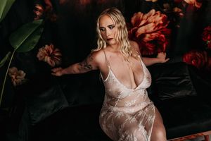 Artistic boudoir photography featuring delicate white lace lingerie against dark floral backdrop. Boudoir Photoshoot Nice & Naughty Boudoir