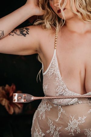 Close up view of intricate white lace detail on sheer lingerie with gold chain strap. Nice & Naughty Store Event Grand Rapids MI Boudoir