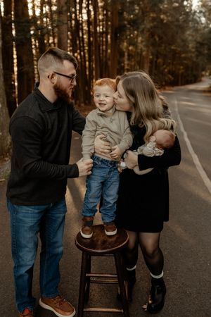 A loving family moment captured in a series of candid photos on a forest road at sunset.