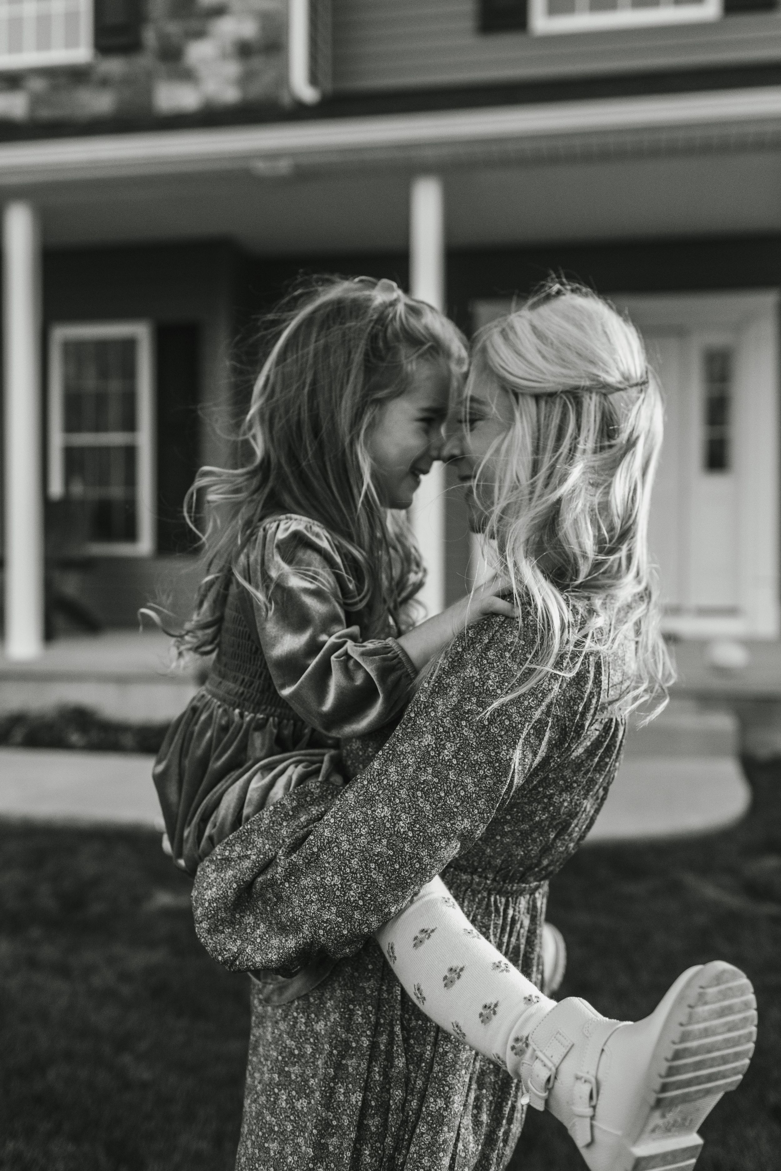 A series of black and white photos showing a child's hair blowing in the wind while wearing a floral dress.