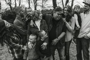 A group of people huddle together outdoors in a black and white photograph.