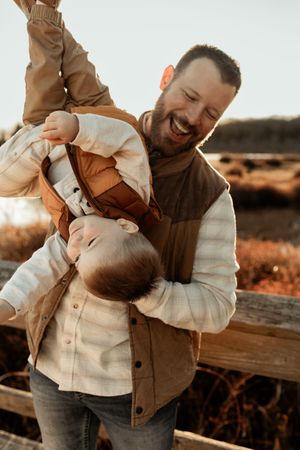Tender family interaction photographed in soft natural light against a rustic outdoor setting.