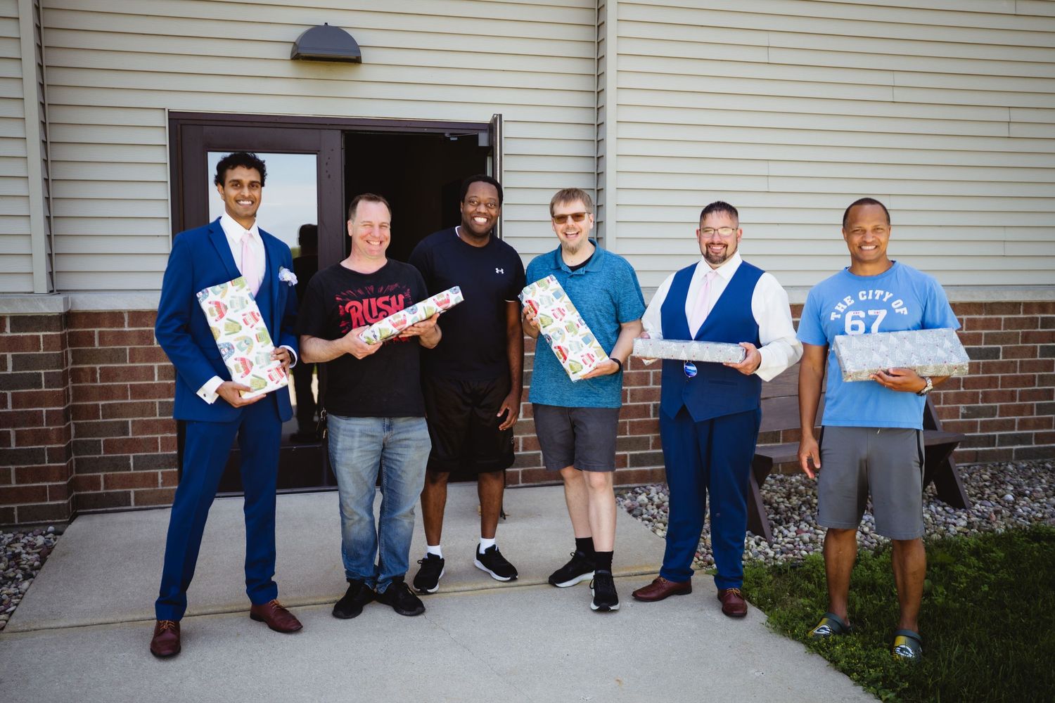 Group of people standing together outside a building while holding awards and certificates.