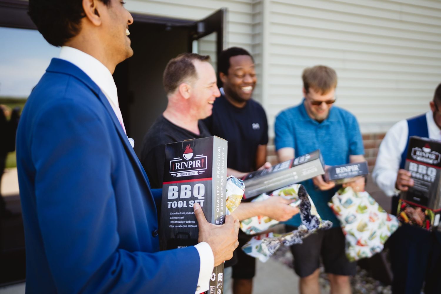 Group of wedding guests in formal attire mingling and socializing during an outdoor reception.