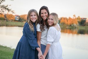 Family members share joyful moments together by a lake during sunset.