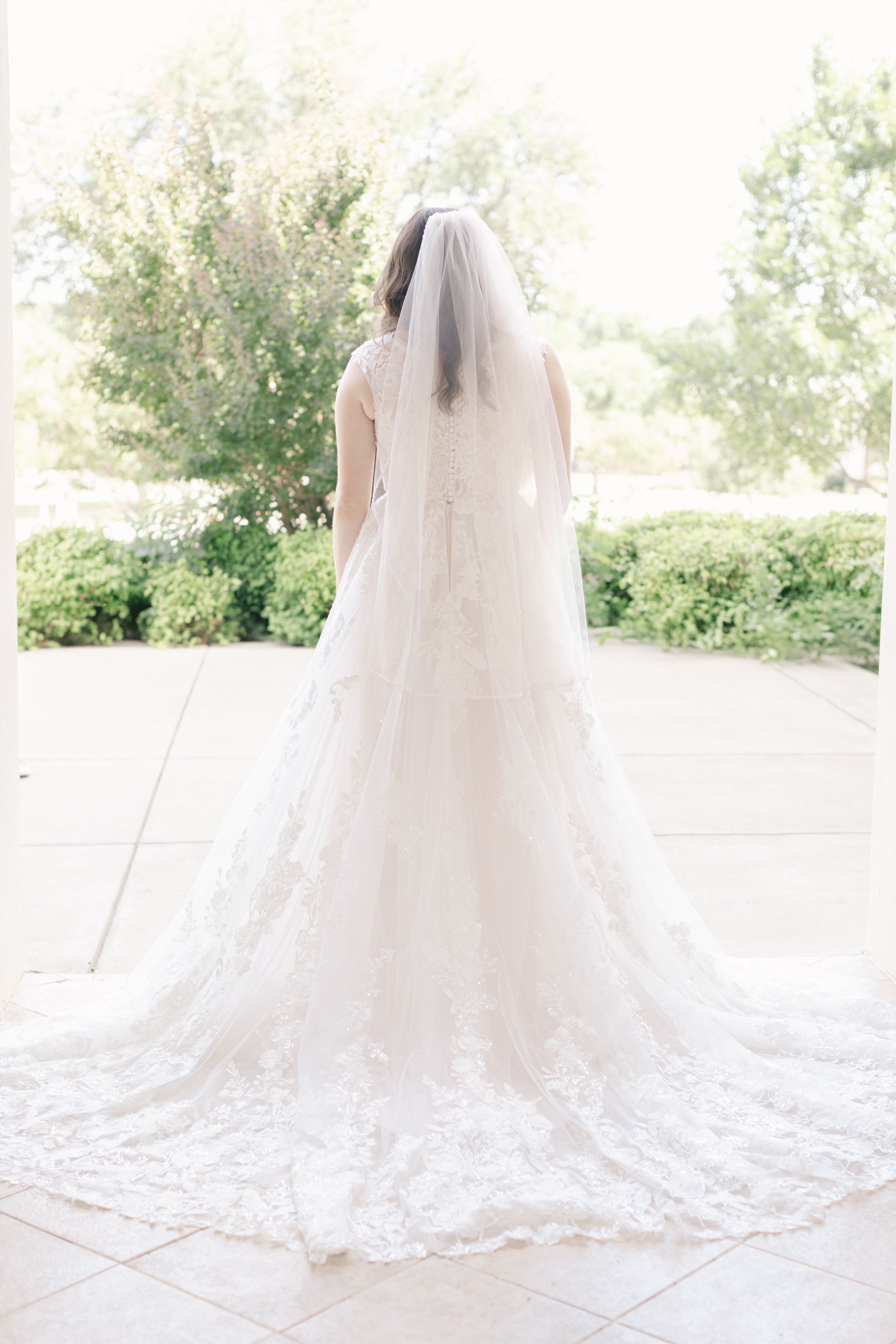 Silhouette of flowing wedding dress train spread beautifully across stone floor.