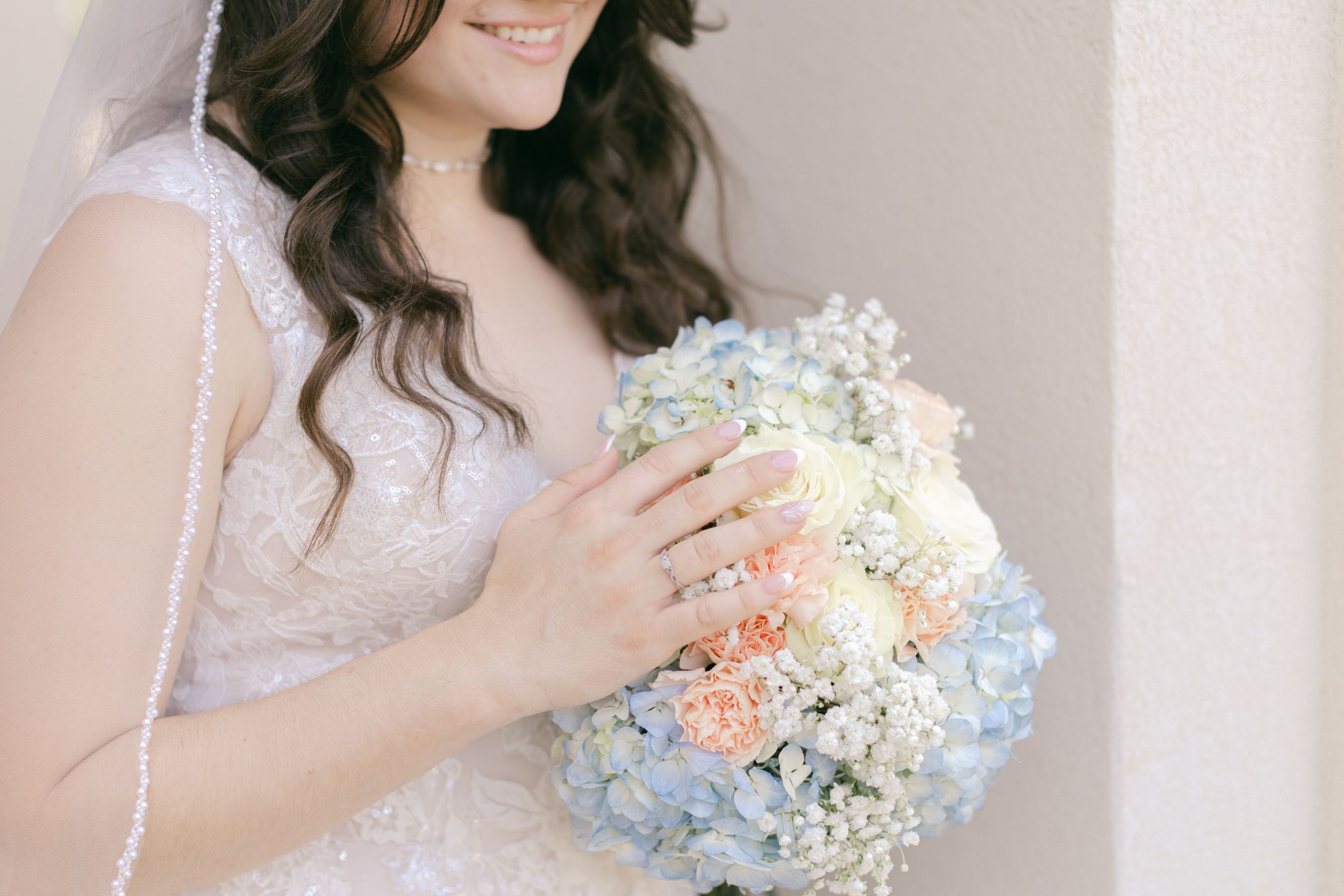 Delicate bridal bouquet featuring soft blue and white flowers.