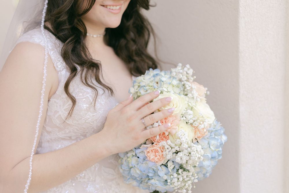 Delicate bridal bouquet featuring soft blue and white flowers.